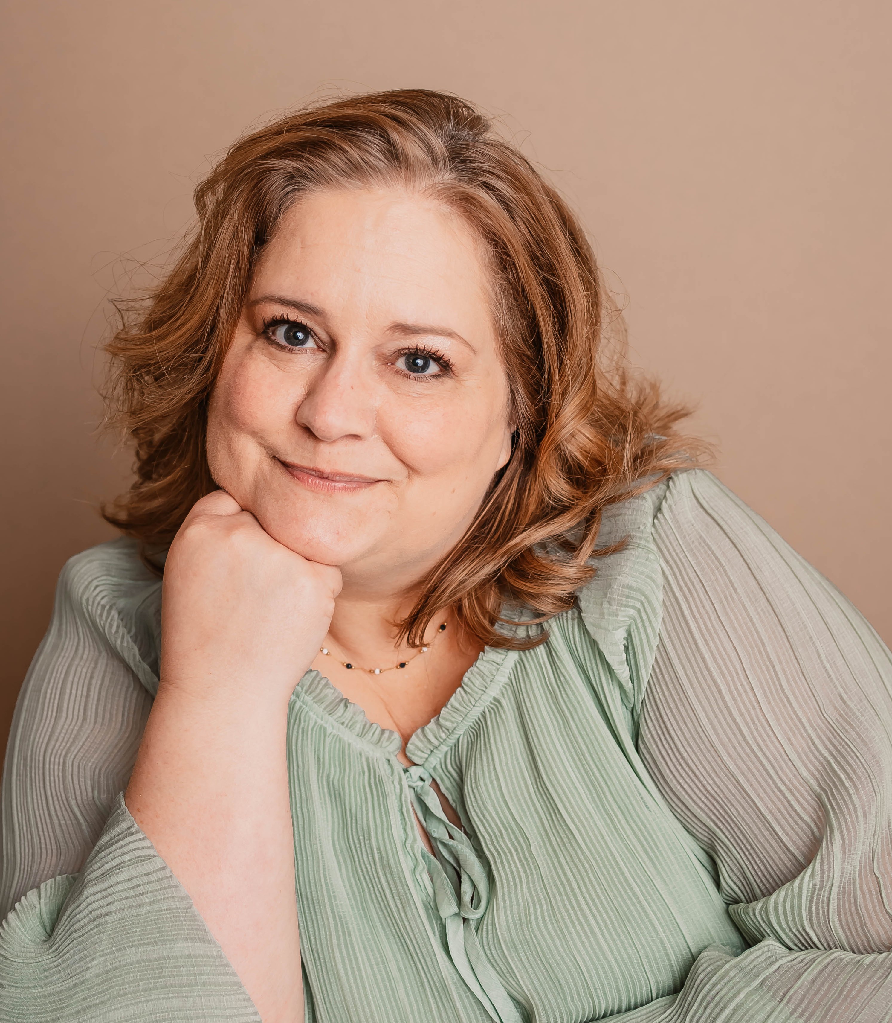 Owner of Solari Head Spa smiling while wearing Solari's signatue green blouse.